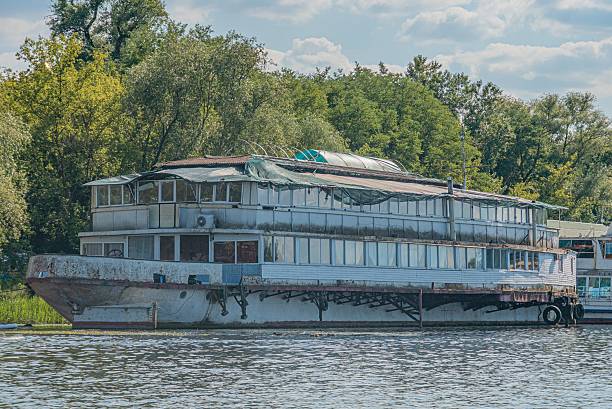 istock Large, white passenger ferry with multiple decks moored on calm waters River or large lake setting White body, dark roof, numerous windows Suggests functionality and comfort for long journeys No 2232860873