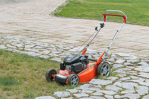 istock Red lawn mower with large wheels on grassy area, possibly a park with concrete path No branding or texts visible Natural lighting, no shadows suggesting harsh sunlight or artificial sources 2232864456