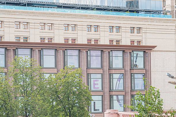 istock Large, orderly modern building in an urban setting Regular window patterns on the facade with a circular symbol Shadows suggest late afternoon lighting Grandeur and permanence 2232865033