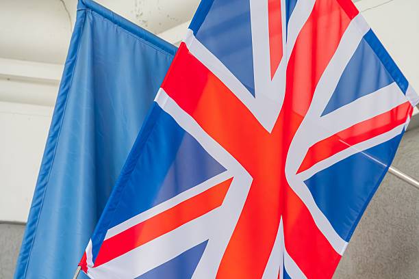istock British and Ukrainian flags hanging from a pole against an interior wall, symbolizing friendship and alliance between the countries The upper flag is predominantly blue with 2232867473
