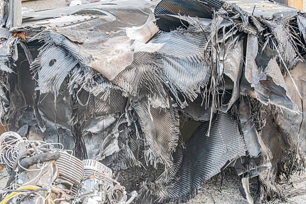 istock A severely damaged, burnt metallic object possibly vehicle or machinery in an urban setting, with exposed wires and natural lighting 2232869056