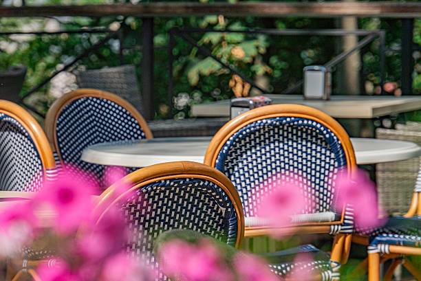 istock Serene outdoor dining scene with blue patterned chairs and a white table in modern urban caf, featuring a small potted pink plant Soft natural lighting 2232870092