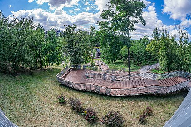 istock Rustic wooden gazebo in a lush urban park with greenery, trees and soft daylight shadows under clear sky a 2232870124
