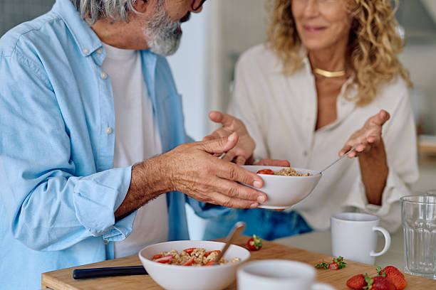 istock Senior man serving breakfast to wife in kitchen 2232871556