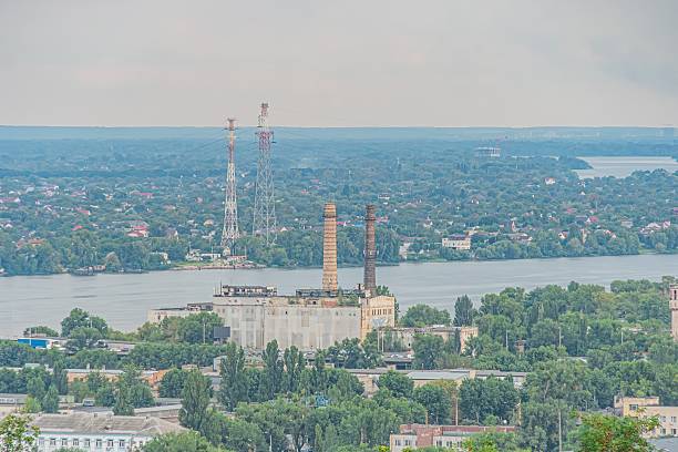 istock Panoramic view of Kyiv cityscape at sunrisesunset, featuring diverse architectural styles and heights, tall towers, residential, commercial, possibly industrial buildings, waterfront setting, greene 2232875779