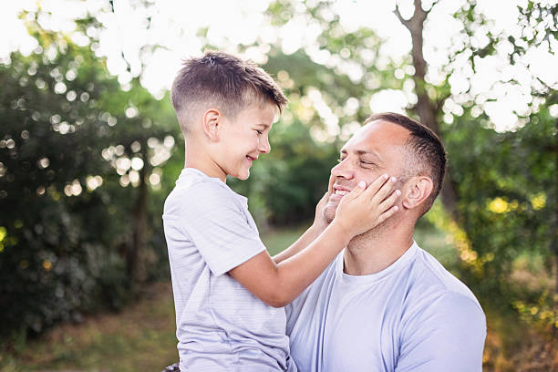 Father and son hugging outdoors, shallow depth of field