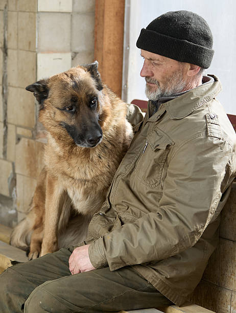 istock Mature man is sitting on a bench with his German Shepherd 2232886941