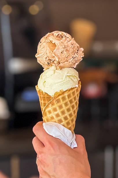 istock Holding a double scoop of ice cream and a  waffle cone 2232890244