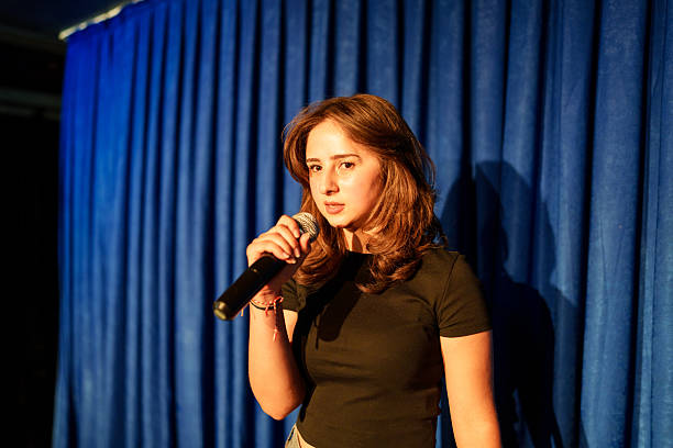 istock Woman holding a microphone on stage. 2232894772
