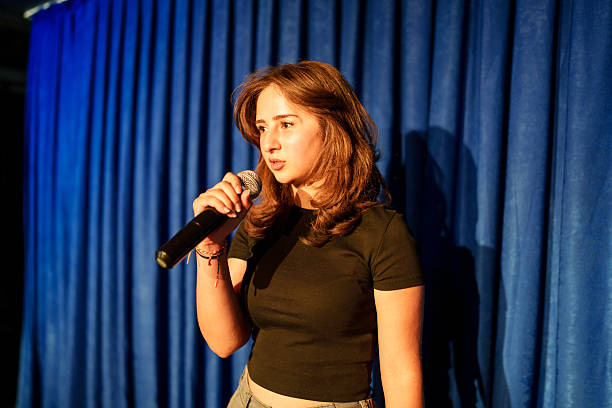 istock Woman holding a microphone on stage. 2232895278