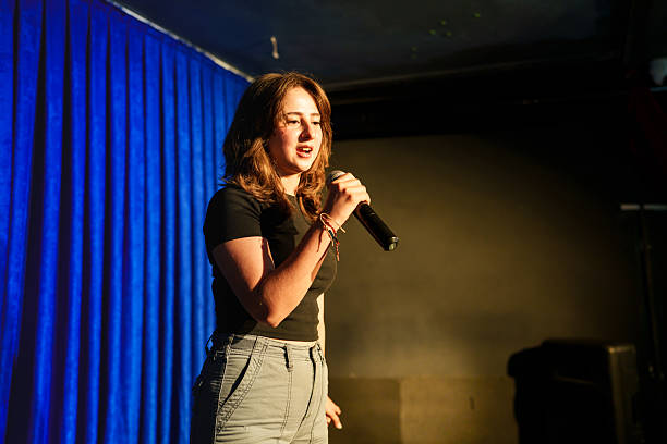 istock Woman holding a microphone on stage. 2232895291