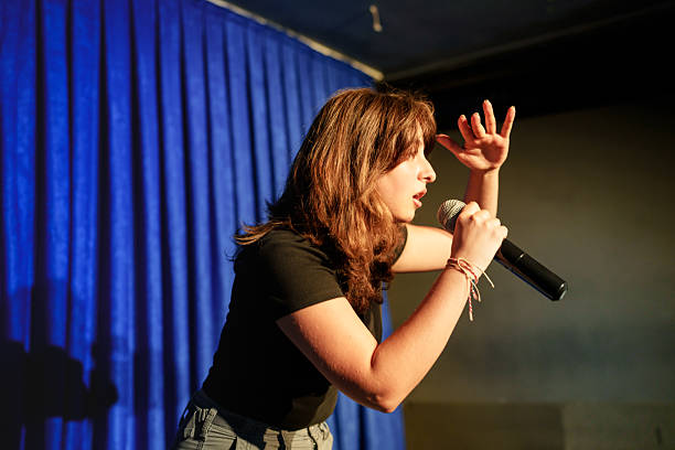istock Woman performing on stage with microphone and hand gestures 2232895938