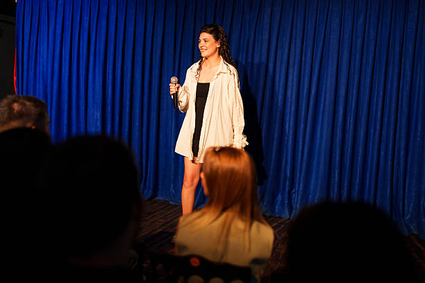 istock Woman performing on stage with microphone in front of audience 2232896724
