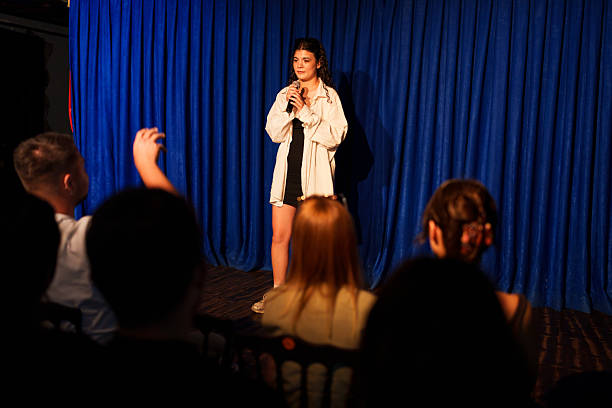 istock Woman performing on stage with microphone in front of audience 2232896735