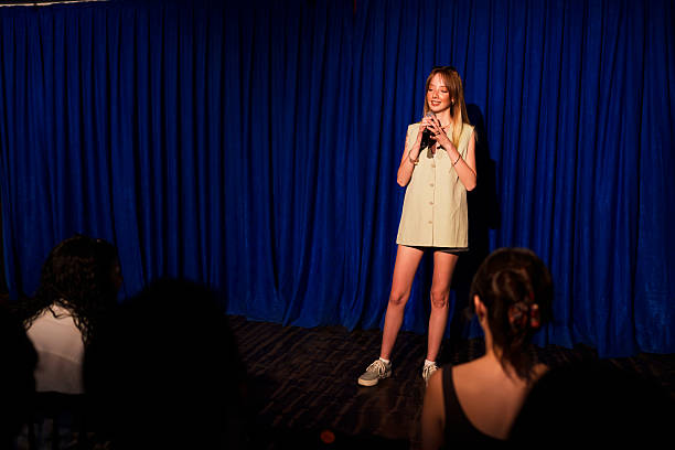 istock Woman performing on stage with microphone in front of audience 2232898403