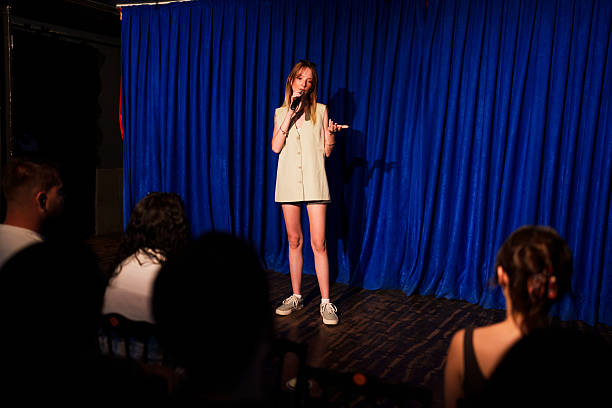 istock Woman performing on stage with microphone in front of audience 2232898409