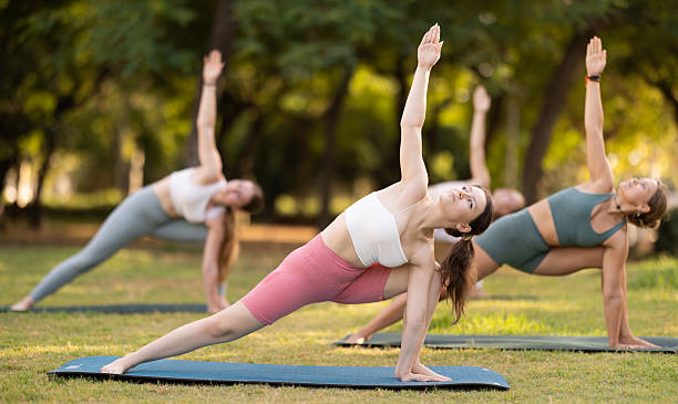 istock Slim women practicing yoga  virabhadrasana pose in summer park 2232899010