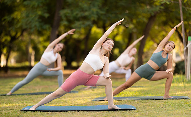 istock Slim women practicing yoga  virabhadrasana pose in summer park 2232899012
