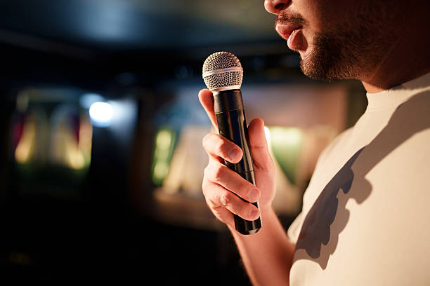 Close-up of man speaking into microphone on stage