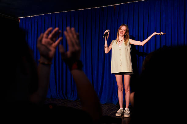 istock Woman performing on stage with microphone in front of audience 2232899226