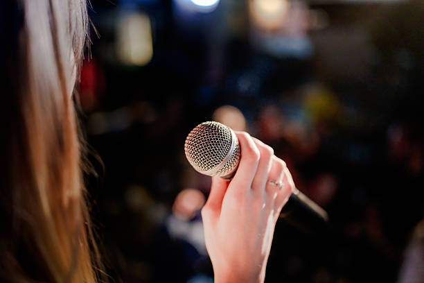 istock Close-up of performer holding microphone on stage 2232899695