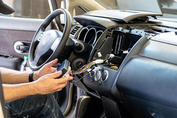 istock Service worker installing car multimedia system and repairing dashboard wiring, representing automotive electronics, vehicle maintenance, stereo upgrade, professional diagnostics, modern car technology 2232901107