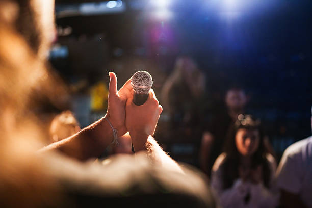 istock Close-up of performer speaking into microphone on stage 2232902866