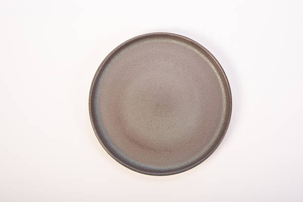 istock Beautiful ceramic plate placed on a white background, selective focus. Top view. 2232905195