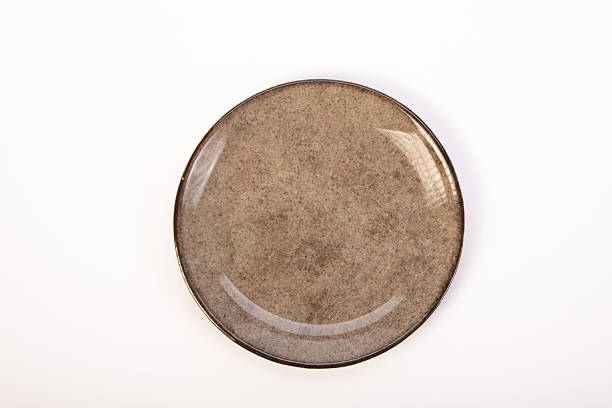 istock Beautiful ceramic plate placed on a white background, selective focus. Top view. 2232905197