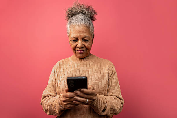 istock Senior woman using the mobile phone in a studio shot 2232907278