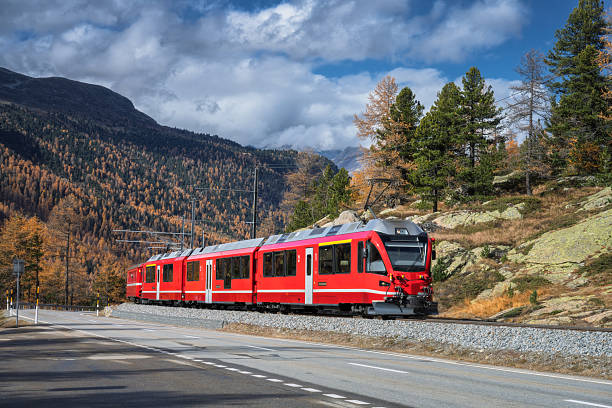 istock Red Bernina Express train passing through colorful autumn forest 2232909745