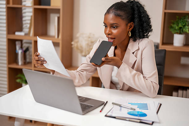 istock Professional woman engages in productive collaboration, using technology to connect with her work. She reviews documents while holding smartphone, showcasing creativity in her workspace 2232914625