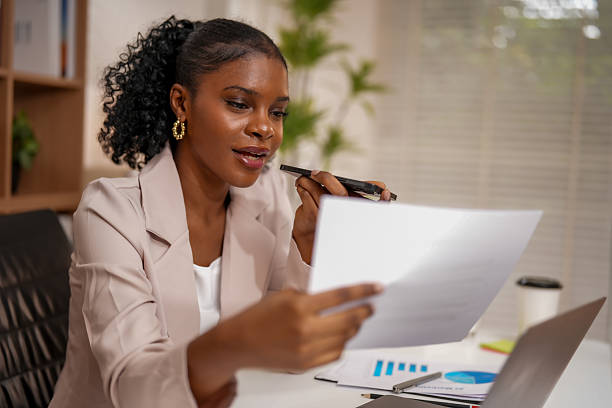 istock Professional woman engages in creative collaboration, utilizing technology to enhance her connection with ideas. She reviews documents thoughtfully, showcasing her focus and determination 2232914632