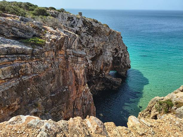 istock A towering cliff with a little cave tunnel 2232917351