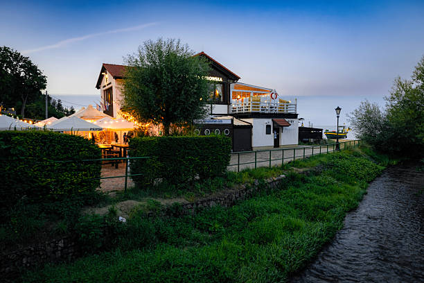 Gdynia, Poland - August 26, 2024: Beautiful historic architecture and summer fish restaurants on the Baltic Sea shore in Gdynia, cliff Orlowo. Tourist destination at evening