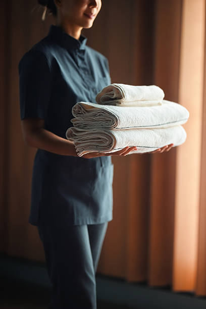 istock Professional Staff Holding Folded White Towels in Spa Environment 2232921138