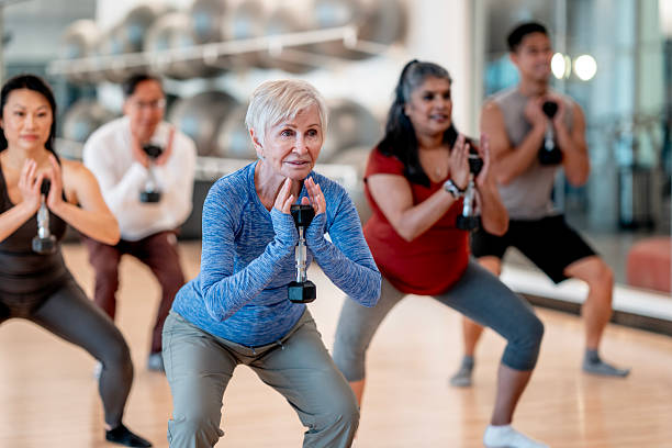 istock Diverse Group in Fitness Class Doing Exercises with Dumbbells at Gym 2232922590