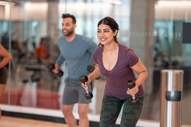 istock Group Workout Session at a Gym with Individuals Using Dumbbells for Exercise 2232922694