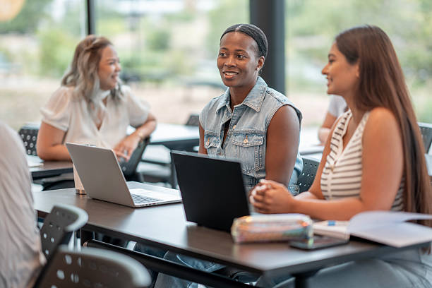 istock Diverse Group of Adults Collaborating at Modern Workspace with Laptops 2232923486