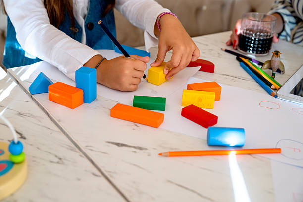 istock Preschool Girl Drawing shapes using wooden blocks, learning geometry 2232924715
