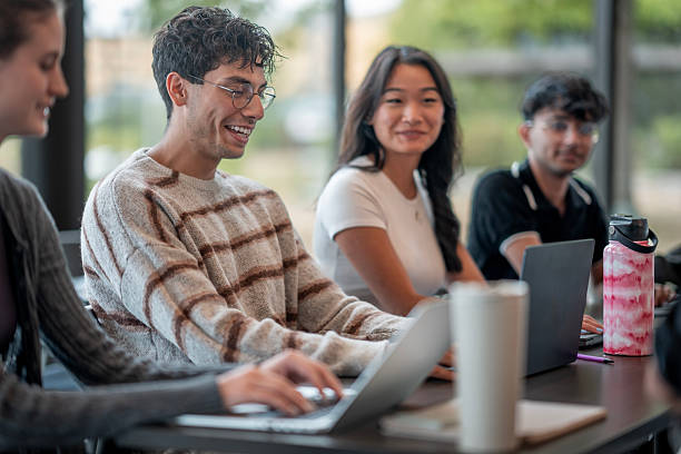 istock Diverse Group of Young Adults Collaborating at Modern Workspace With Laptops 2232926672