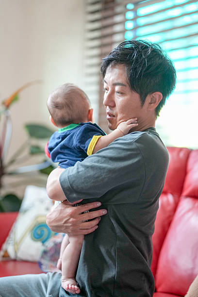istock A man is holding a baby in his arms 2232926775