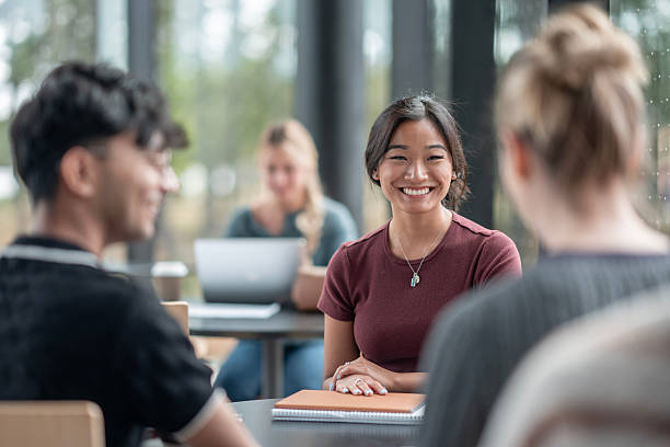 istock Smiling Asian Woman Collaborates with Diverse Peers in a Modern Study Environment 2232929720