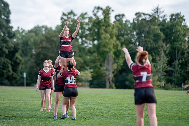 istock Women's Rugby Players Coordinate Training on a Green Field During Practice 2232930284