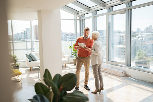 Two business professionals discussing while reviewing information on a tablet in a modern space