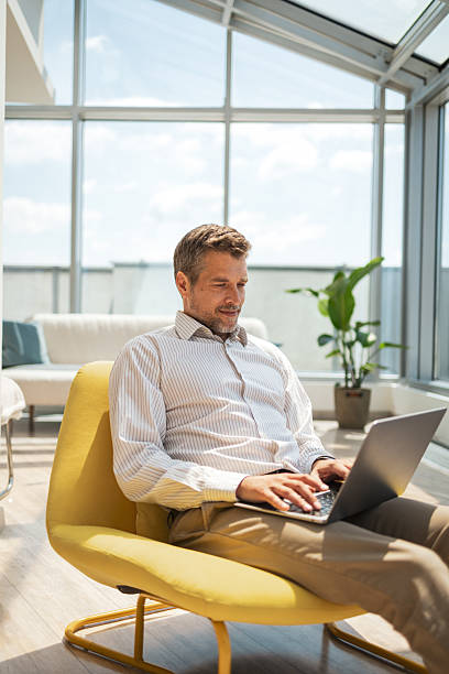 istock Man working on laptop while seated in a modern and bright environment 2232930325