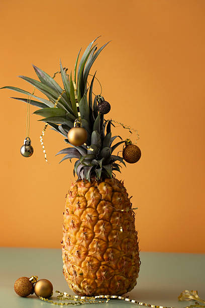 istock A festive twist on holiday decor, this image features a pineapple adorned with golden Christmas ornaments and curly ribbons 2232930558