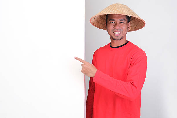 istock Indonesia farmer standing beside blank board and pointing on it with happy face 2232937862