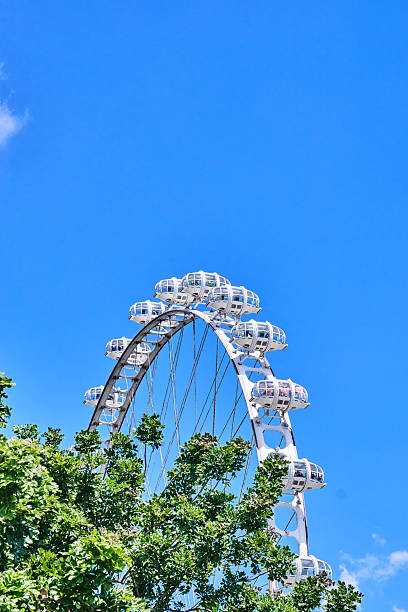 View of the London eye in the centre of London, UK.  People can be seen on the promenade