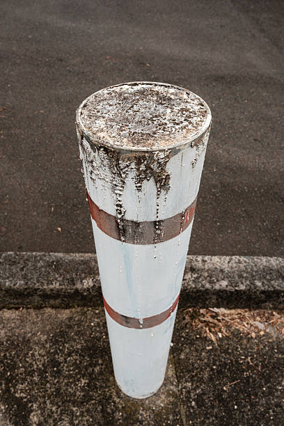 High angle view of an old white metal bollard.